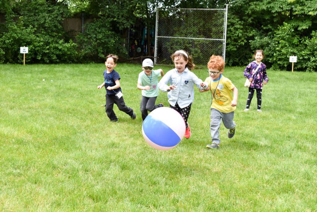 Three boys running after a ball.