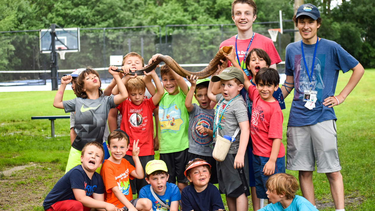 Young campers and counselors posing with a snake.