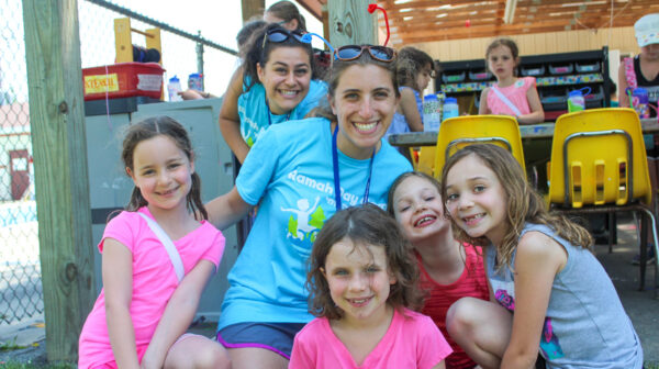 Girls posing with a camp counselor.