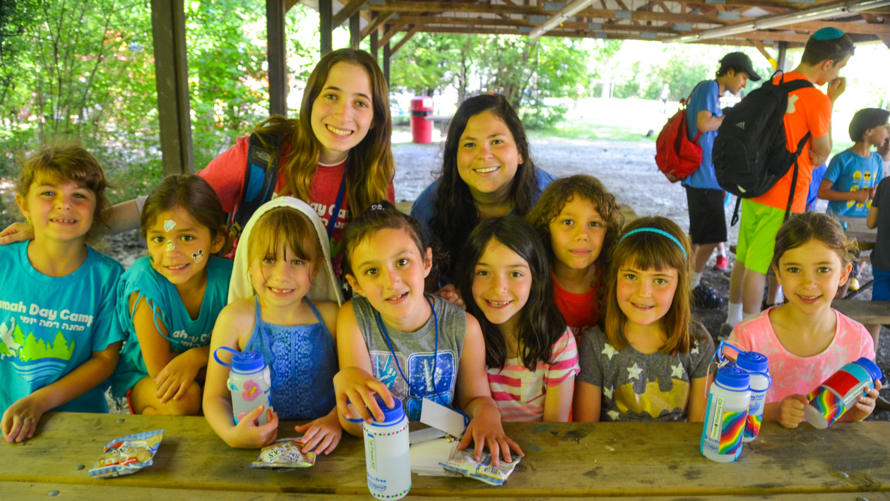 A group of campers sitting at a picnic table.