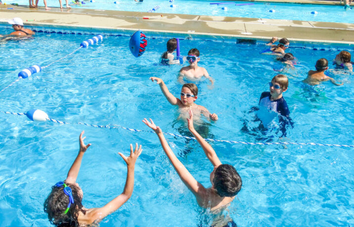 Kids playing in an outdoor pool.