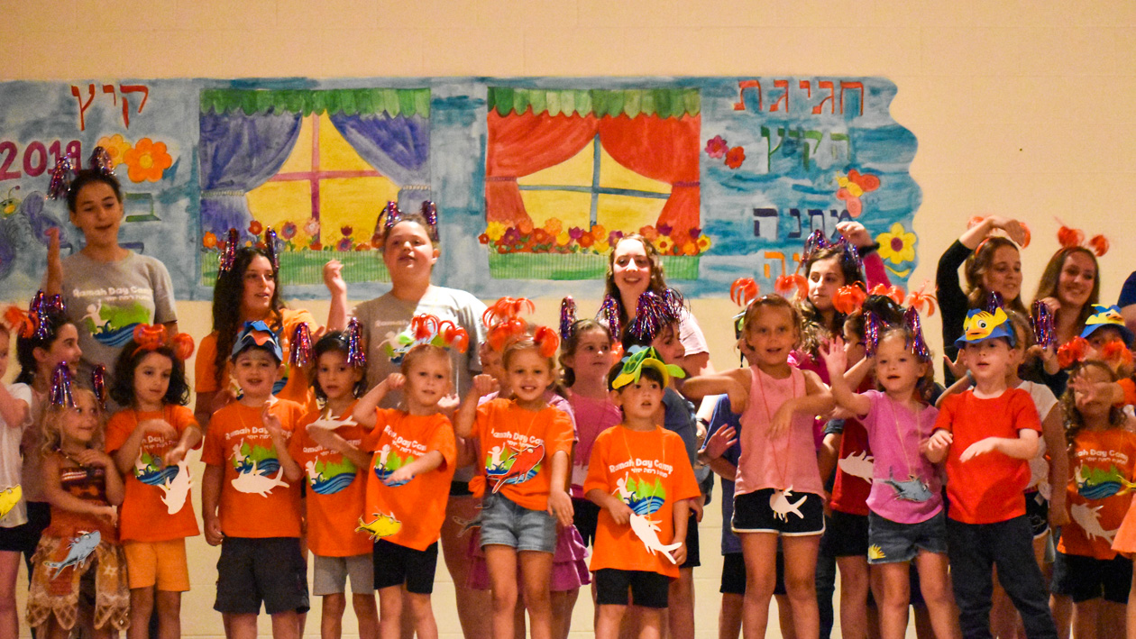 A group of kids wearing orange shrits.